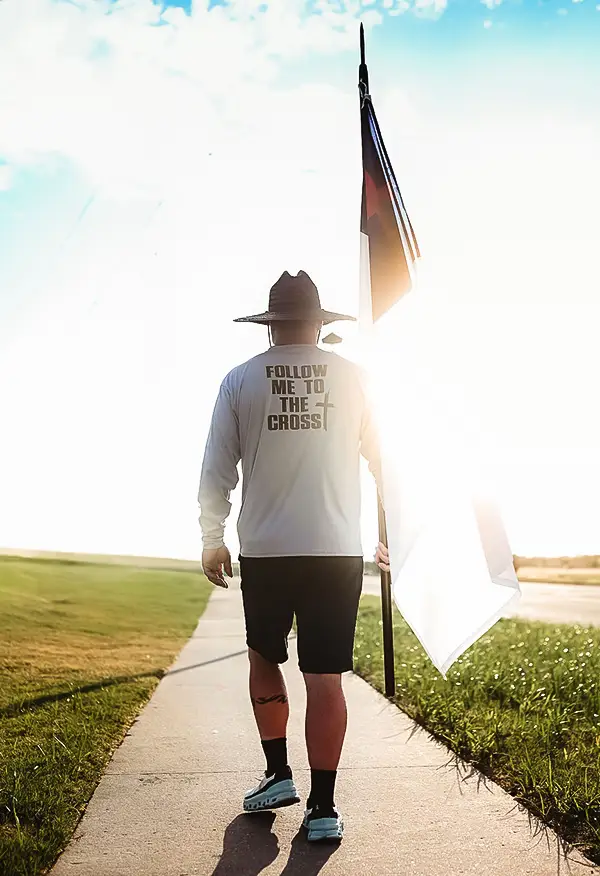 John Miller walks with the Christian flag to raise money for Coworkers Ministry.